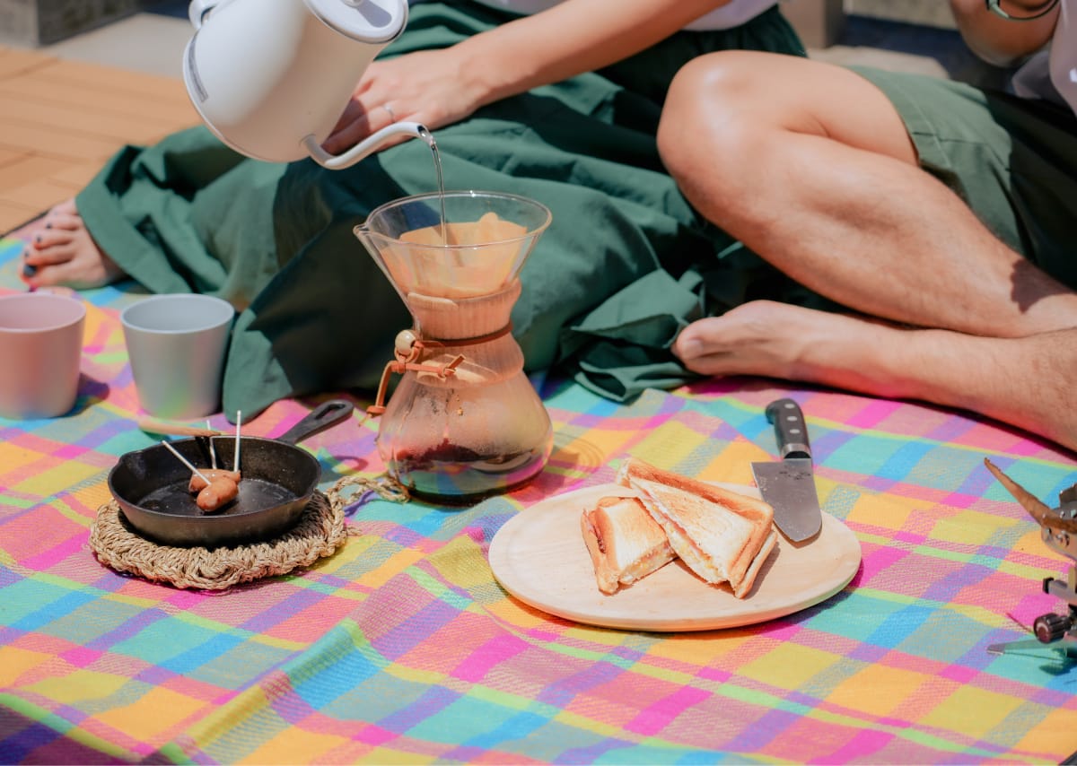 バルコニーでコーヒーを淹れている様子。隣にはホットサンドがあります。